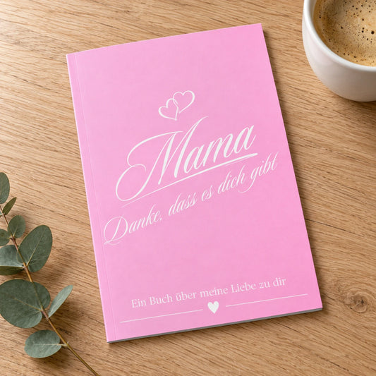 Buch Mama – Danke, dass es dich gibt, rosa Einband, auf einem Eichentisch neben einer Tasse Kaffee