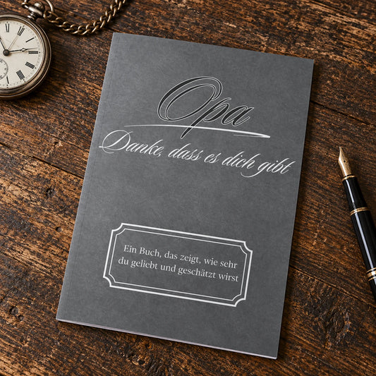 Buch Opa – Danke, dass es dich gibt, anthrazitfarbener Einband, auf einem Schreibtisch neben Taschenuhr und Füller