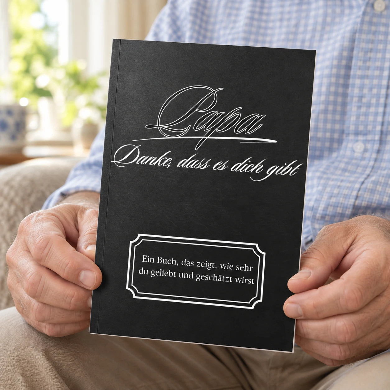 Mann hält das schwarze Buch Papa – Danke, dass es dich gibt in den Händen
